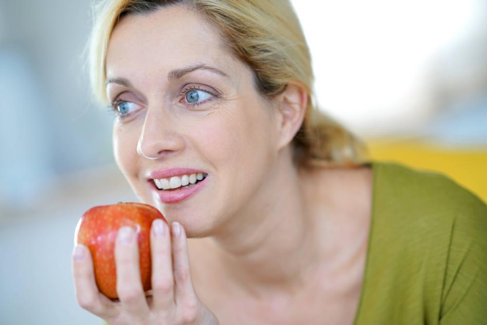 woman eating apple with sensitive teeth in charotte nc 