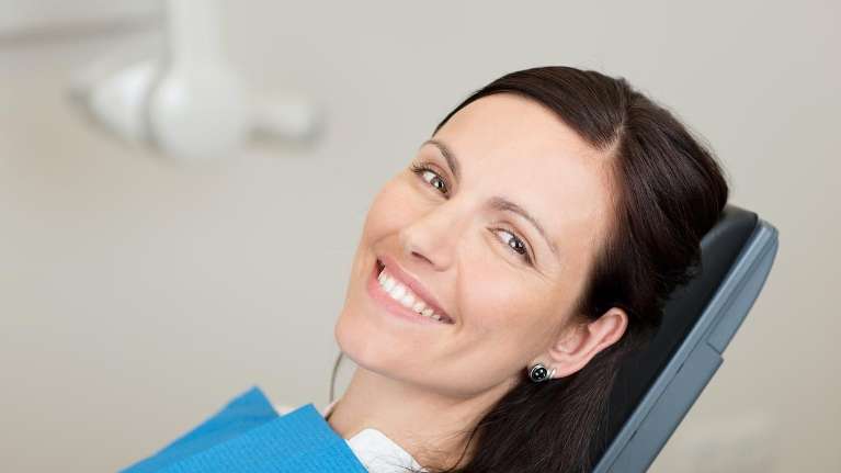 woman in dentist chair smiling | dental fillings charlotte nc