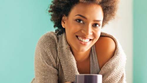 Black woman smiling with a coffee cup, charlotte nc